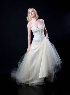 tam uzunlukta portre beyaz model giyen gelin topu cüppe, ayakta poz siyah arka plan üzerine.