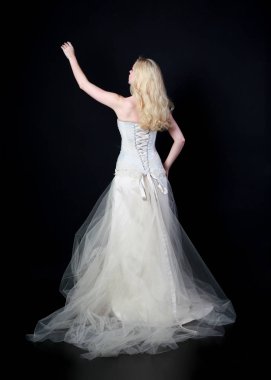 tam uzunlukta portre beyaz model giyen gelin topu cüppe, ayakta poz siyah arka plan üzerine.