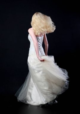 tam uzunlukta portre beyaz model giyen gelin topu cüppe, ayakta poz siyah arka plan üzerine.