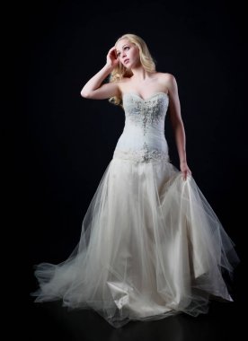 tam uzunlukta portre beyaz model giyen gelin topu cüppe, ayakta poz siyah arka plan üzerine.