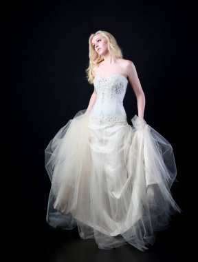 tam uzunlukta portre beyaz model giyen gelin topu cüppe, ayakta poz siyah arka plan üzerine.