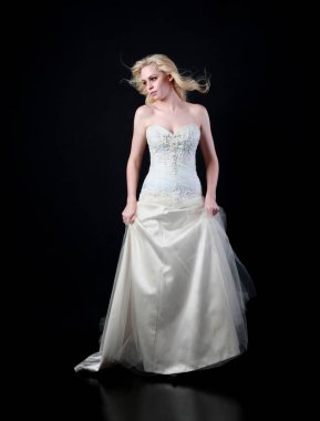 tam uzunlukta portre beyaz model giyen gelin topu cüppe, ayakta poz siyah arka plan üzerine.