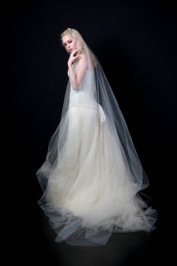 tam uzunlukta portre beyaz model giyen gelin topu cüppe, ayakta poz siyah arka plan üzerine.