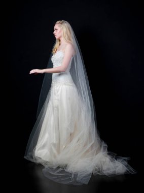 tam uzunlukta portre beyaz model giyen gelin topu cüppe, ayakta poz siyah arka plan üzerine.