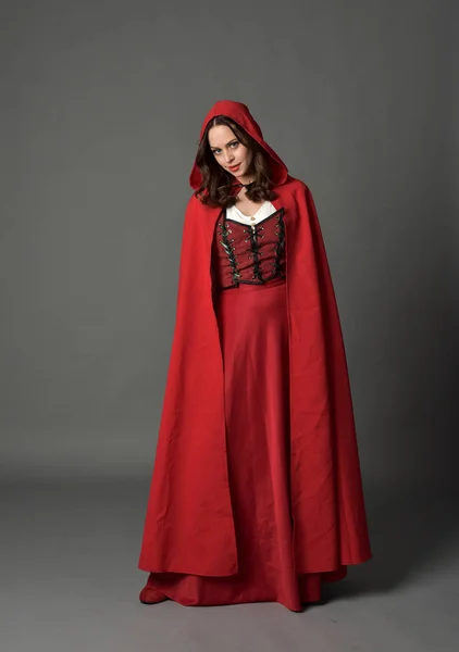 穿着红色梦幻服装的黑发女士全长肖像 在灰色演播室背景上站立姿势 — 图库照片