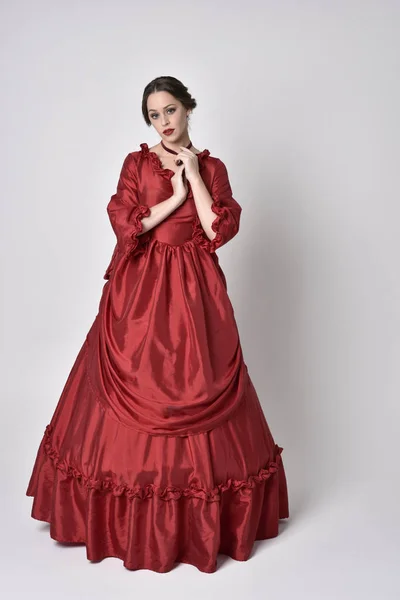 Portrét Brunetky Červených Hedvábných Viktoriánských Šatech Stojící Póza Bílém Pozadí — Stock fotografie