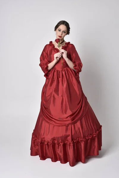 Portret Brunetki Czerwonej Jedwabnej Wiktoriańskiej Sukni Stojąc Tyłem Kamery Białym — Zdjęcie stockowe