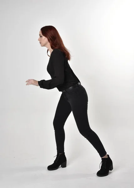 Beautiful brunette girl in the studio wearing black leggings and grey  jumper Stock Photo - Alamy