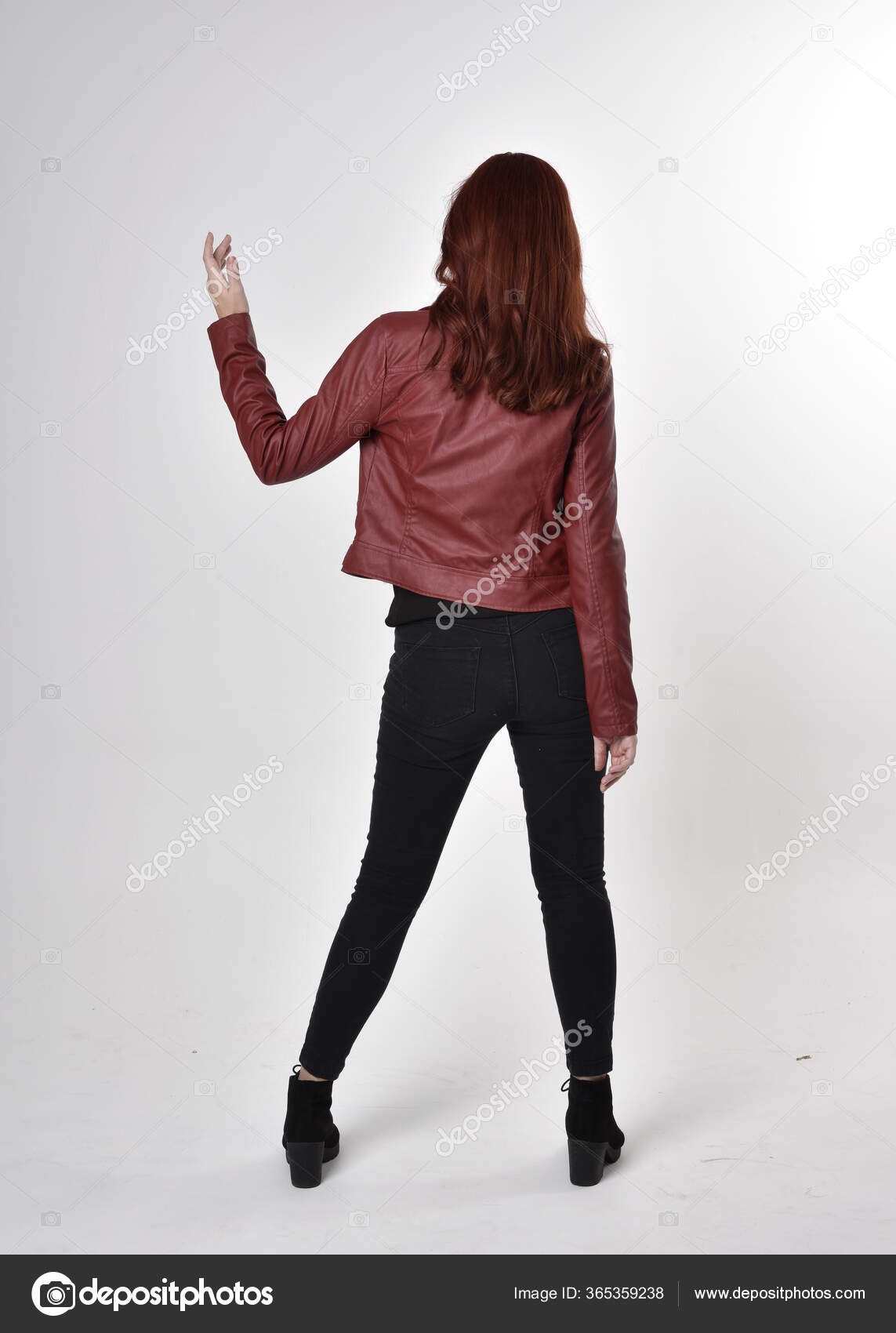 一个红头发的漂亮女孩穿着黑色牛仔裤和皮夹克靴子的画像全长站立姿势背对着相机有工作室背景 图库照片 C Faestock 一个红头发的漂亮女孩穿着黑色牛仔裤和皮夹克靴子的画像全长站立姿势背对着相机有工作室背景 图库照片 C Faestock