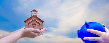 Anne ve oğul el ele tutuşuyorlar. Mavi kumbara, güneş ışığı ve...