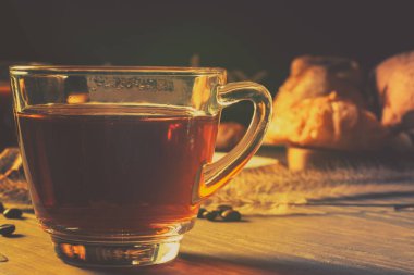 Temiz fincanda sıcak kahve, fırın ve kahve çekirdeği ev yapımı ekmek dilimlenmiş ekmek, Fransız ekmeği, kenevir torbasında kahve çekirdeği ve ahşap masaya yerleştirilmiş keklerden oluşur. Poster ve reklam amaçlı kullanılır.