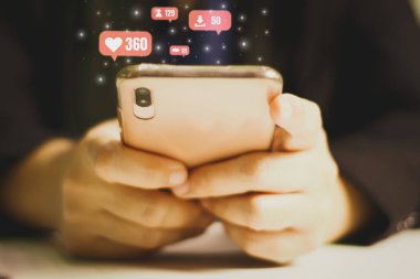 Genç bir kadın akıllı telefonuyla günlük hikayeyi akıllı telefonlu ve kamuoyuna paylaşmak için el ele tutuşuyor, arka planda pembe renk simgeleri, kablosuz ağları kullanarak sosyal medyayı güncellemek için konsept kullanıyor.