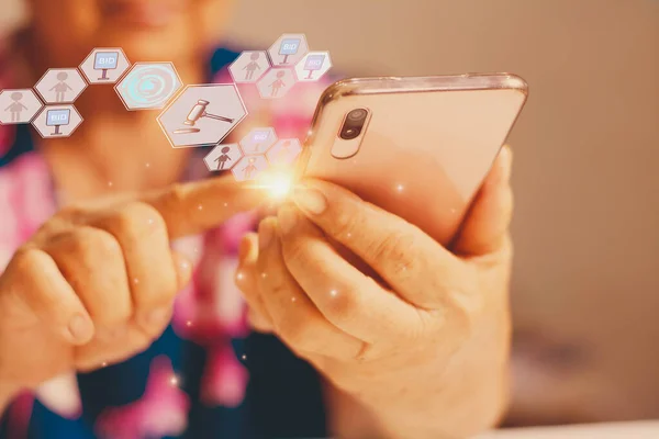 Elderly woman use hand holding smart phone enter price bid via wireless network, blue bokeh background with auction icon, Concept online auction via website, application and modern technology