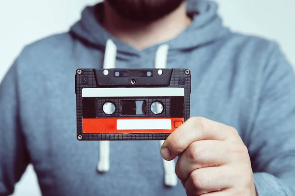 Teyp kasetiyle tutan el. Teyp kasetiyle kullanılır. Ses kaset. El Vintage ses kaset dokunun. Eski kaset kaset ses üzerinde beyaz izole.