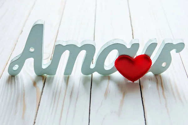 love, love. red heart and the word amour on a white wooden background