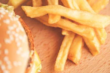 Hamburger ve patates kızartması bir ahşap tahta üzerinde yakından
