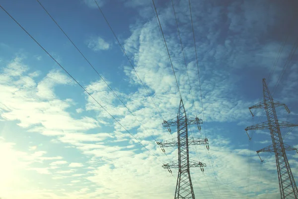 Elektrische leidingen tegen de blauwe lucht en de witte wolken — Stockfoto