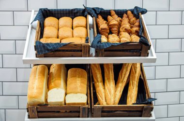 Fırındaki raflarda farklı taze ekmek var.