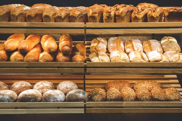 Diferentes pan fresco en los estantes de la panadería —  Fotos de Stock