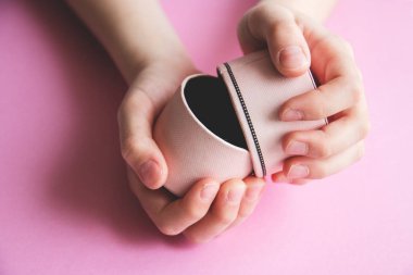 Kız s eller üzerinde pembe bir arka plan, küçük Prenses için sürpriz bir hediye kutusu açın