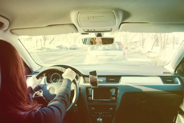 La mujer de cabello castaño conduciendo un coche en un día soleado —  Fotos de Stock