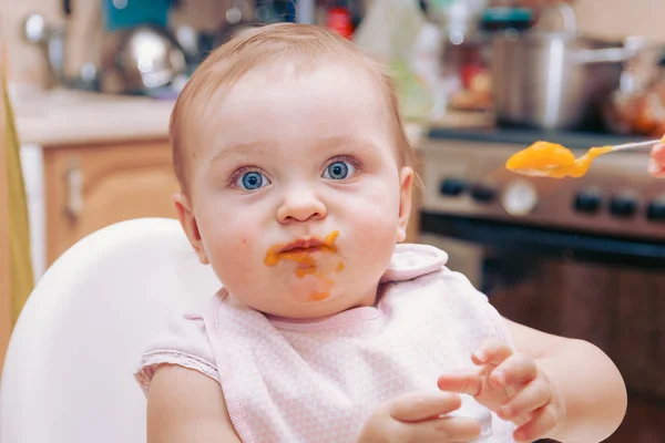 Retrato de feliz jovem bebê no alta cadeira sendo alimentado — Fotografia de Stock