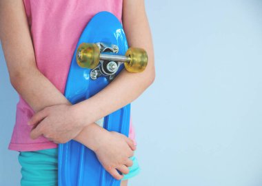 duvara karşı bir mavi paten ayakta tutan kız