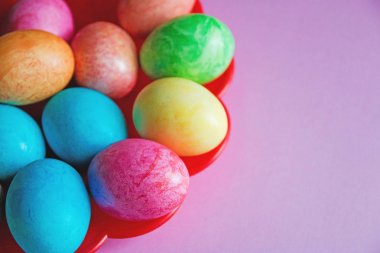 pembe bir arka plan üzerinde kırmızı plaka üzerinde parlak renkli Paskalya yumurta