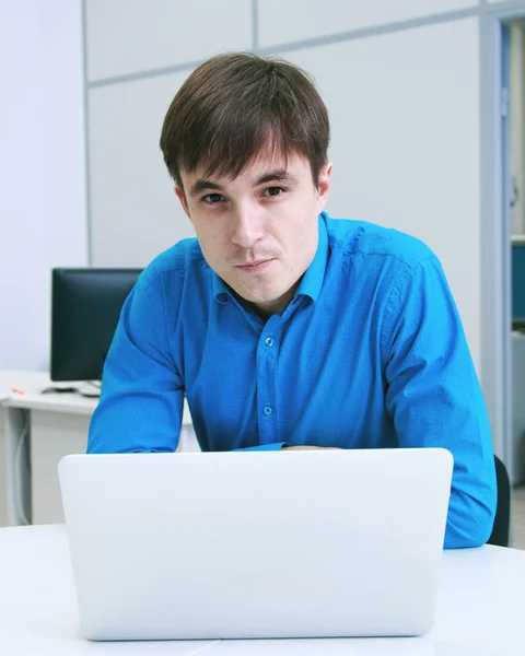 Smilling portrait of a man in front of a laptop computer in office — Stock Photo, Image