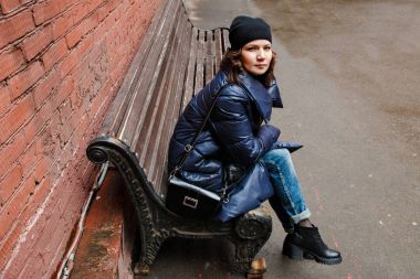 bir bankta oturan gülümseyen kız