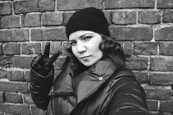 黒い帽子で巻き髪の女の子は、レンガの壁、ストリート写真 selfie — ストック写真