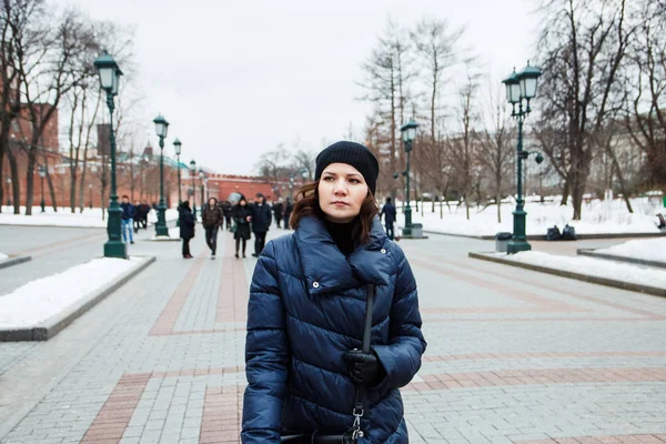 人々 の背景の都市の路上でコートの少女の肖像画 — ストック写真