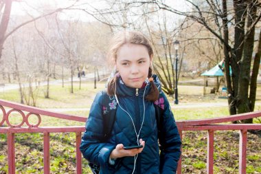 sıcak güneşli havalarda sırt çantası Aracı'nda müzik dinlerken kulaklık ile sokakta ile kız öğrenci