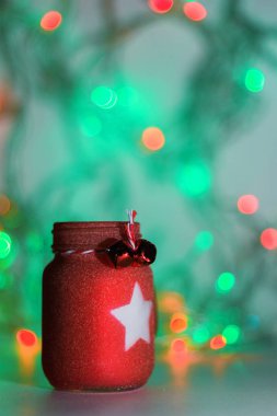 Renkli arka planda izole edilmiş dekoratif kırmızı mum. Noel arkaplanı, Noel ve Yeni Yıl ruhu