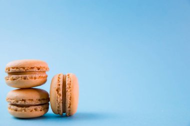 Turkuaz arka plan üstü, renkli badem kurabiyeleri, seçici odak