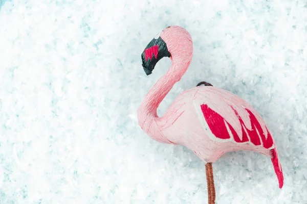 Рожевий фламінго на бірюзовому фоні зі снігом, вибірковий вид зверху — стокове фото