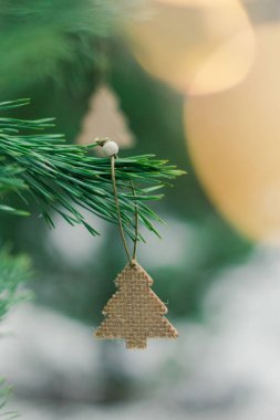 Parlak Noel şenlik arka planı, kozalaklı ağaç, basit Noel süslemeleriyle süslenmiş, çelenkten parlak bokeh ışığı.