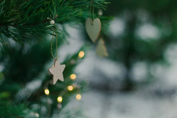Parlak Noel şenlik arka planı, kozalaklı ağaç, basit Noel süslemeleriyle süslenmiş, çelenkten parlak bokeh ışığı.