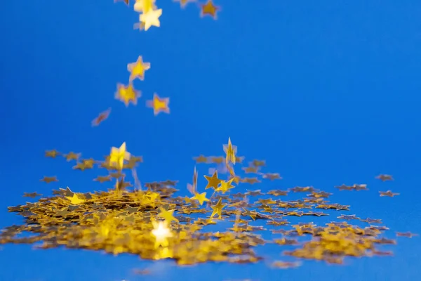 Luminoso sfondo festivo, puntelli flatlay stelle sbriciolanti su sfondo blu copiare spazio — Foto Stock