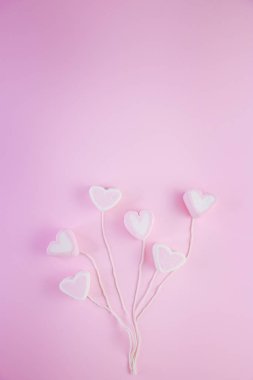 Pastel Valentine arka planı, pembe arkaplandaki bir ipteki kupa şeklinde şekerleme suflesinden yapılmıştır. Kopya alanı ile Sevgililer Günü konsepti