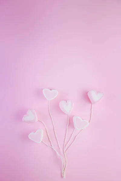 Pastel Valentine background is made of marshmallow souffle in the form of hearts on a string on a pink background. Valentine's day concept with copy space — Stock Photo, Image