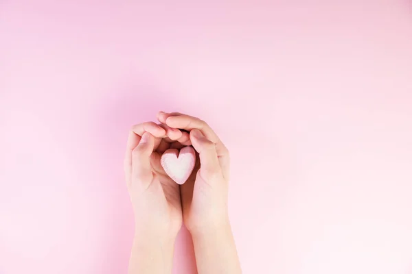 Pastel valentine background made of marshmallows souffle in the form of hearts on a pink background in hands. Valentine's Day concept with copy space — Stock Photo, Image