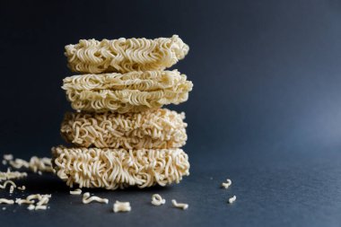A stack of homemade instant noodles rewound with a blue rope on a black background