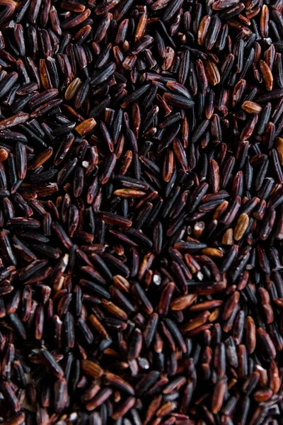 Black wild rice close-up background texture top view, selective focus