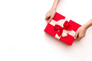 Beyaz arka plan manzaralı, elinde güzel bir kurdele olan hediye kutusu. Sevgililer Günü için tebrik kartı