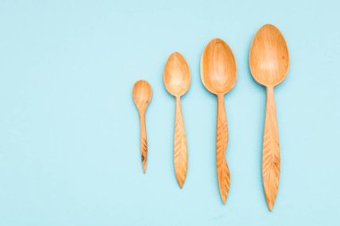 Ev eşyaları: ahşap mutfak aletleri, mavi arka plan manzarasında izole edilmiş. Sıfır atık, çevre dostu konsept. Düz yatıyordu.