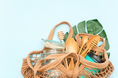 Pamuk torbası, cam kavanoz, yeşil yapraklar ve geri dönüşümlü masa örtüsü manzaralı plastik set. Sıfır atık, çevre dostu konsept. Düz yatıyordu.