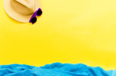 Sarı arka plan şapkalı aksesuarlar, plaj özellikleri ve hayali mavi deniz. Yukarıdan bakıldığında seyahat ya da boş zaman kavramı. Yaz arkaplanı.
