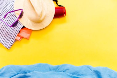 Sarı arka plan şapkalı aksesuarlar, plaj özellikleri ve hayali mavi deniz. Yukarıdan bakıldığında seyahat ya da boş zaman kavramı. Yaz arkaplanı.