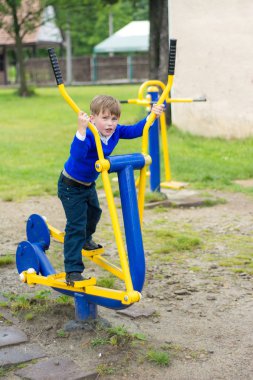 Harika bir Ukraynalı çocuk egzersizleri simülatörleri üzerinde gerçekleştirir.